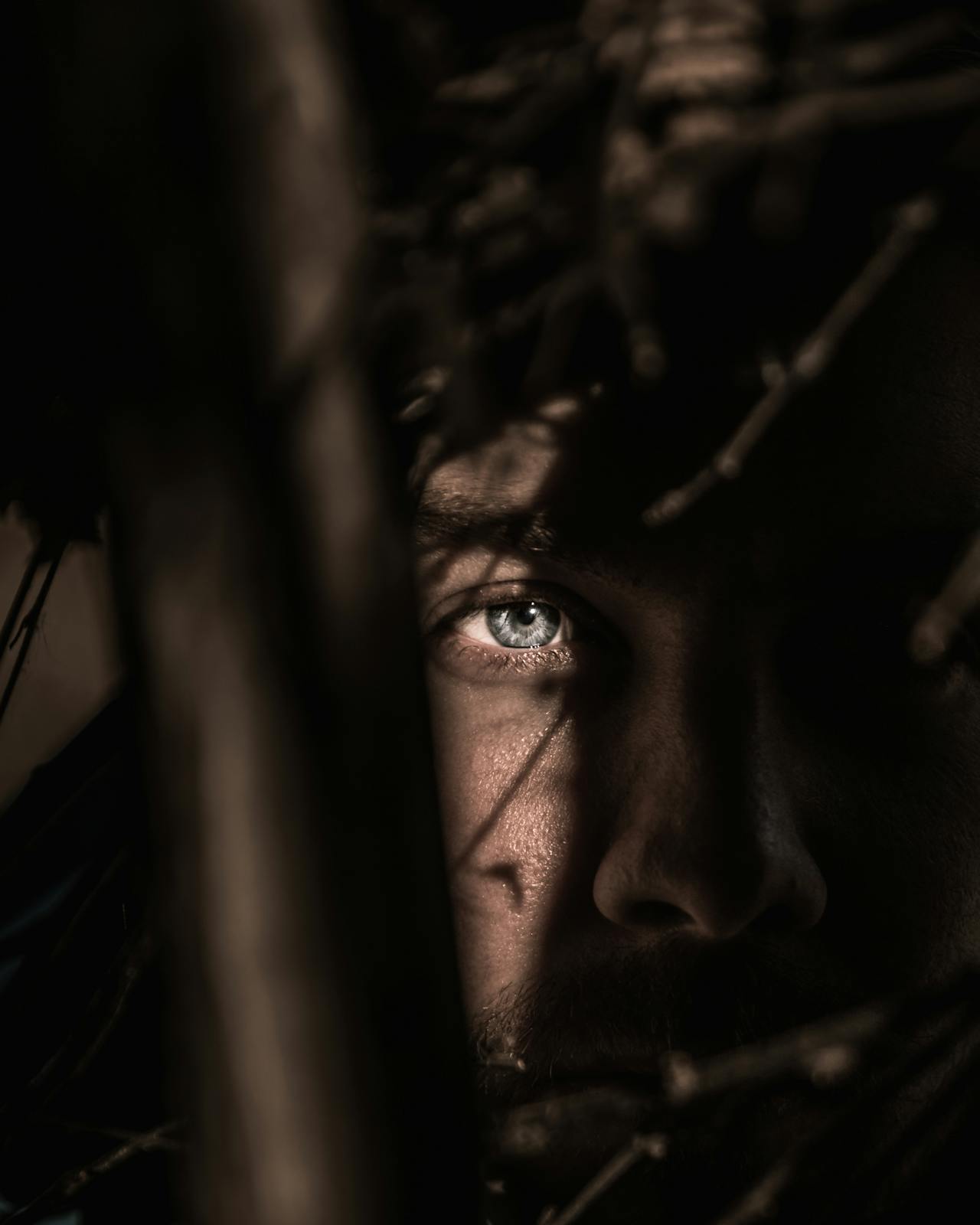 Man hiding behind something, with his eye showing through.