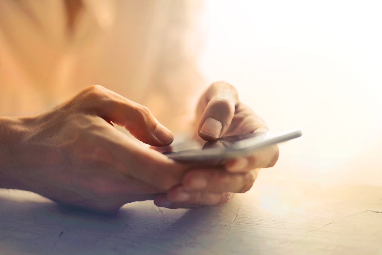 Two hands holding a cell phone.